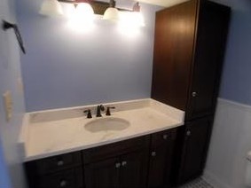 Custom build cabinets were made for the space.  We used mahogany and stained it dark with period correct glass knobs.  The countertop and backsplash are Carrera marble with an under-mount sink. 
